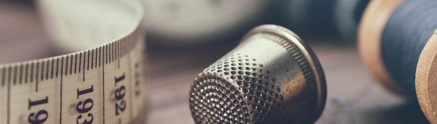 Sewing accessories: sewing meter, thimble and needle.